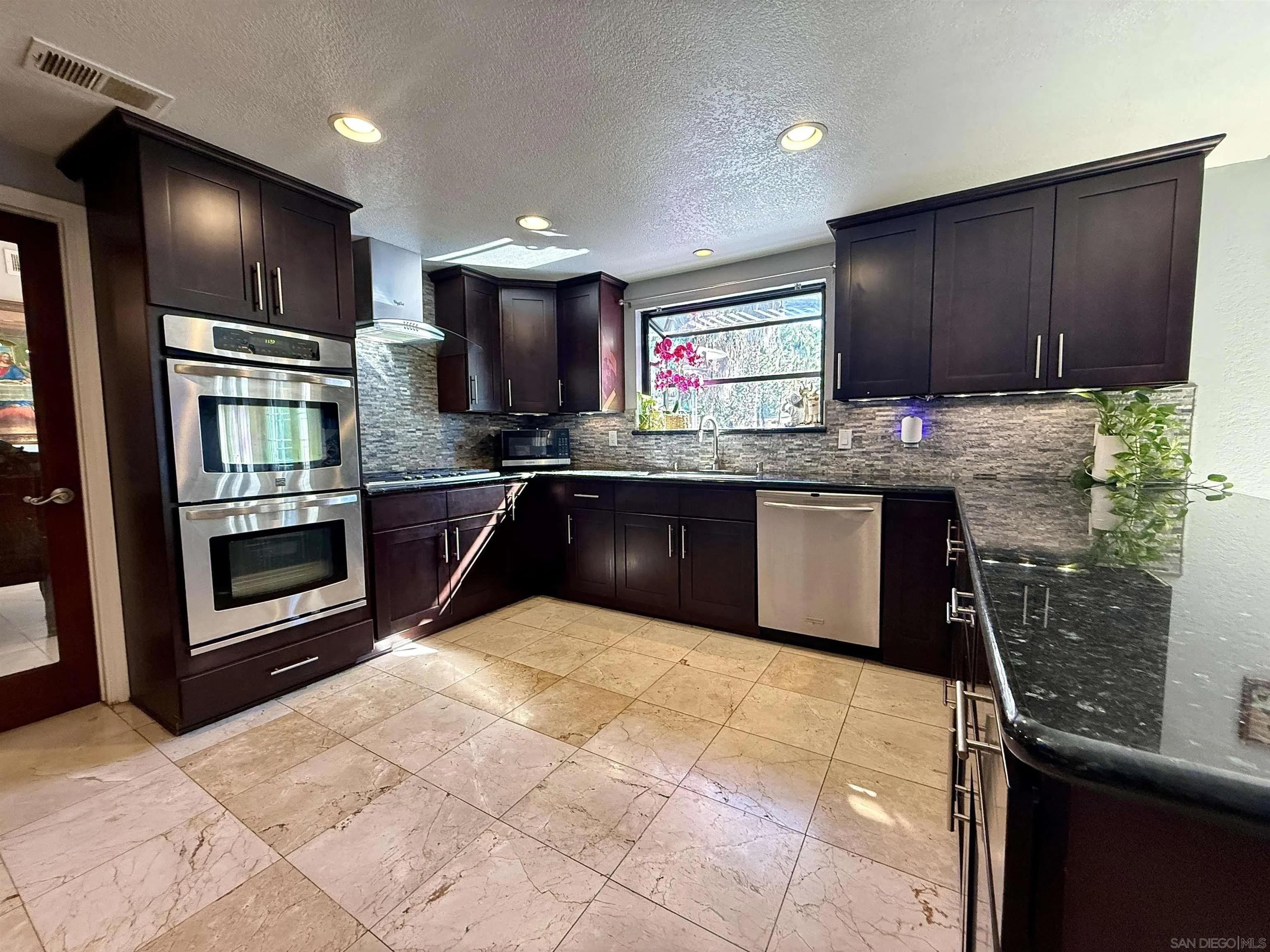 1423 Vista Grande Road El Cajon, CA 92019 - Photo 6 of 25 a kitchen with stainless steel appliances granite countertop a sink and stove top oven