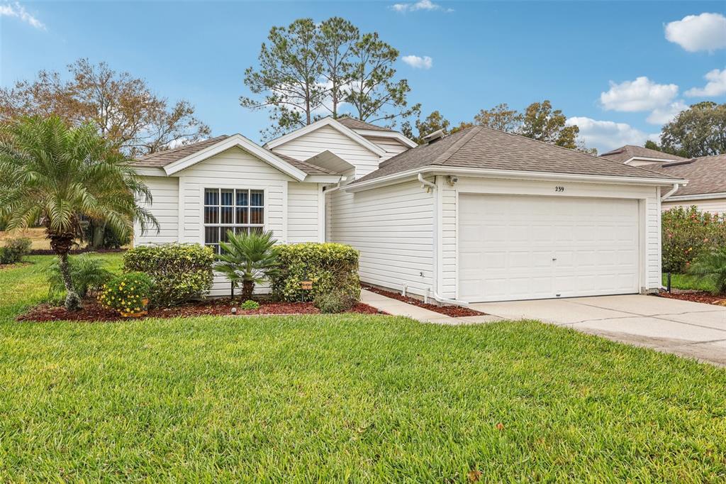 239 Juniper Way Tavares, FL 32778 - Photo 2 of 45 a front view of a house with a yard and garage