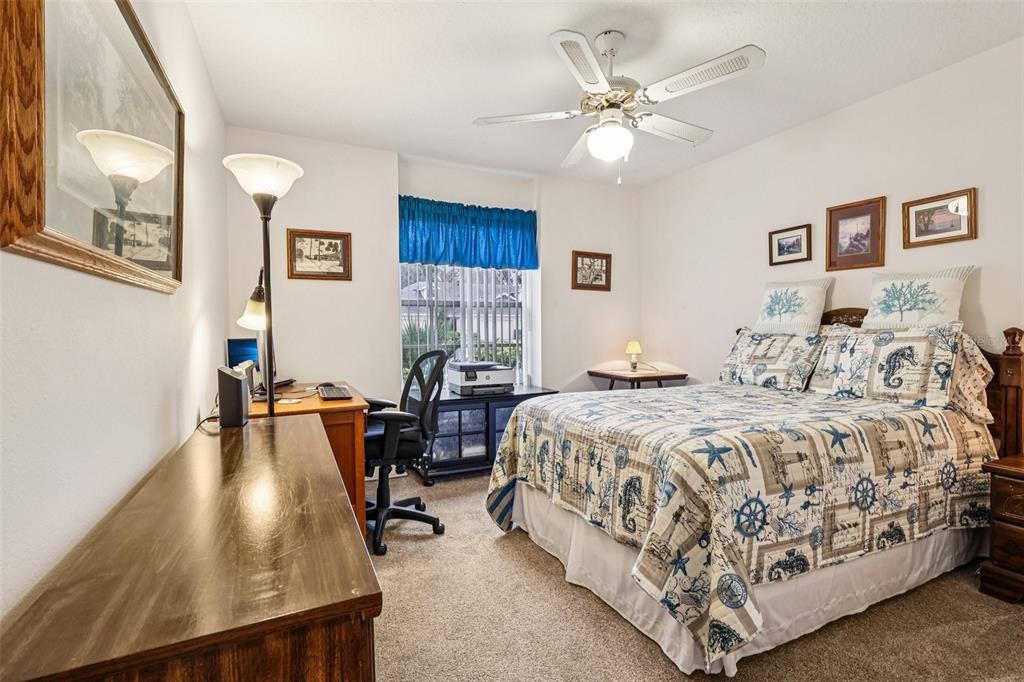 239 Juniper Way Tavares, FL 32778 - Photo 23 of 45 a spacious bedroom with a bed a desk and chair with wooden floor