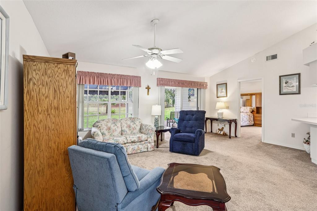 239 Juniper Way Tavares, FL 32778 - Photo 9 of 45 a living room with furniture ceiling fan and a window