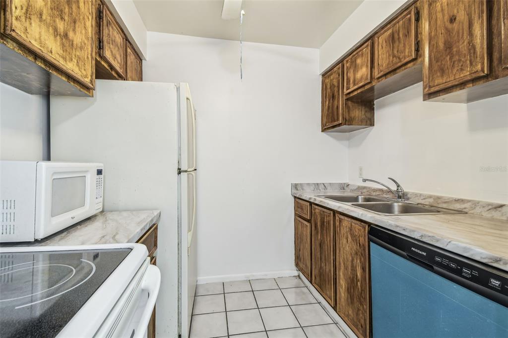 4208 Winding Moss Trail, Unit 102 Tampa, FL 33613 - Photo 11 of 27 a kitchen with a sink stove and refrigerator