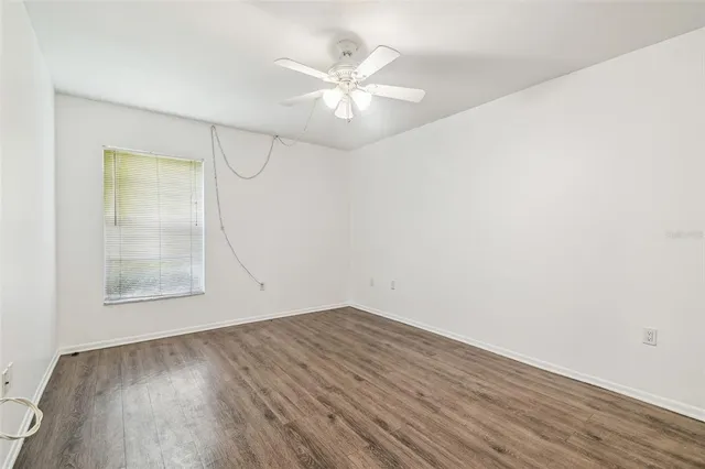 an empty room with a fan and a window