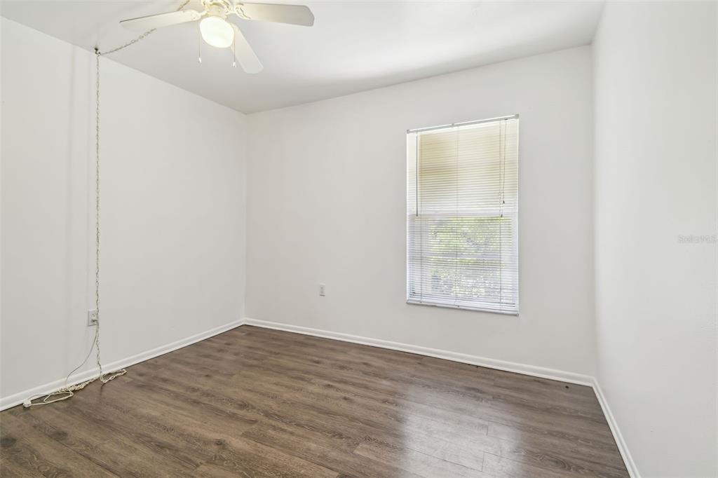 4208 Winding Moss Trail, Unit 102 Tampa, FL 33613 - Photo 16 of 27 an empty room with wooden floor and windows