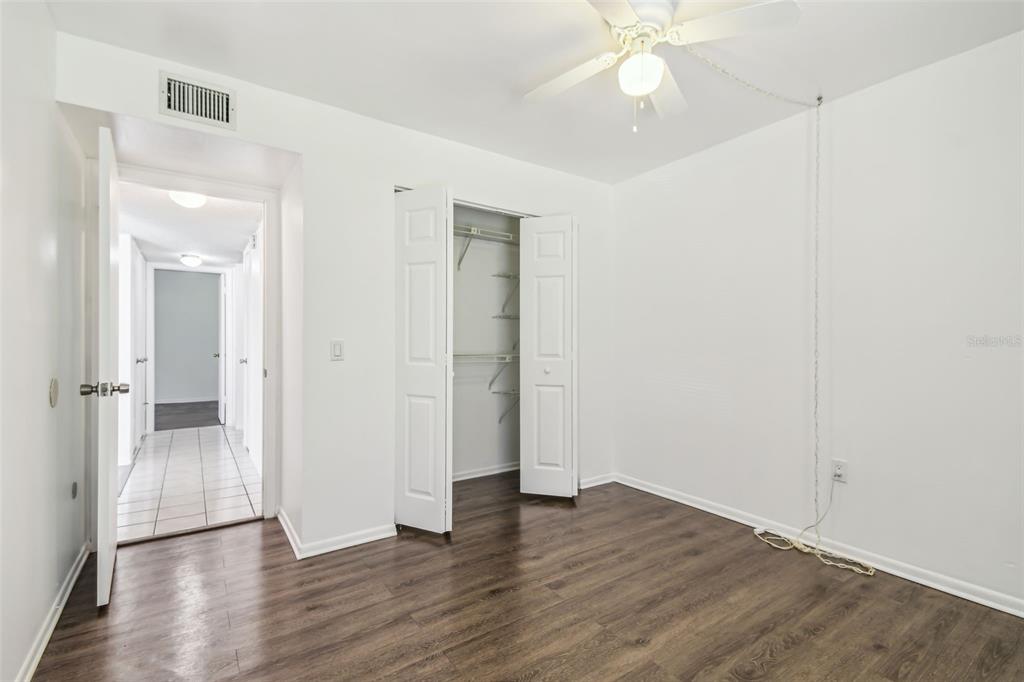 4208 Winding Moss Trail, Unit 102 Tampa, FL 33613 - Photo 17 of 27 an empty room with wooden floor and a ceiling fan