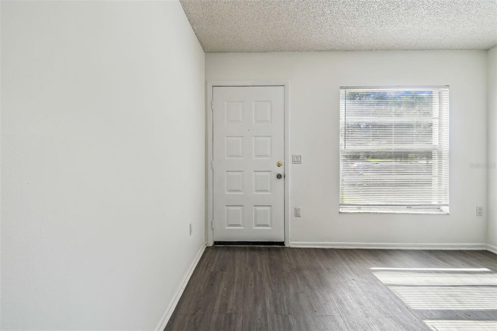 4208 Winding Moss Trail, Unit 102 Tampa, FL 33613 - Photo 6 of 27 a view of an empty room with wooden floor and a window