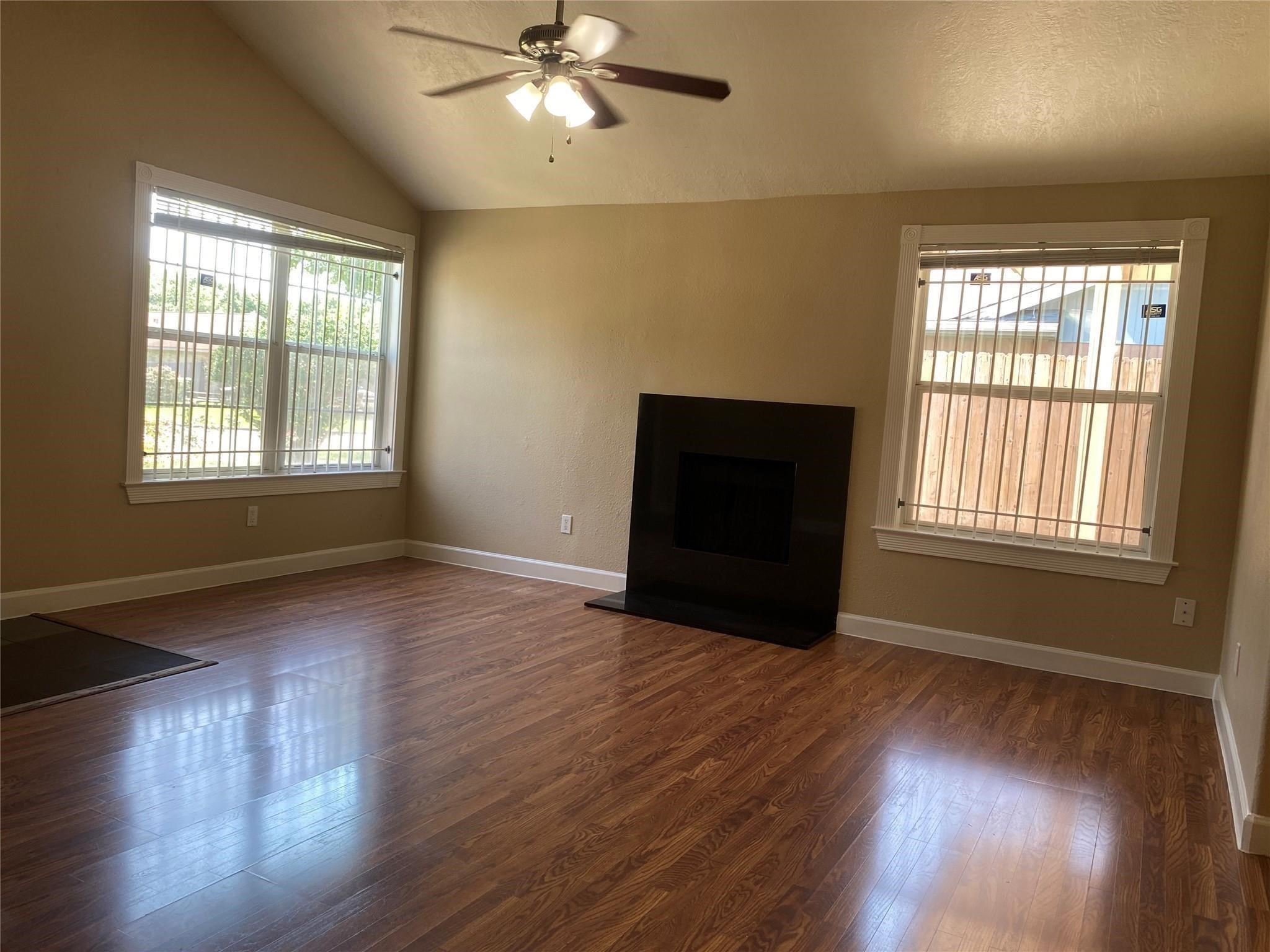 3226 Brookston Street Houston, TX 77045 - Photo 2 of 24 a view of an empty room with wooden floor and a window
