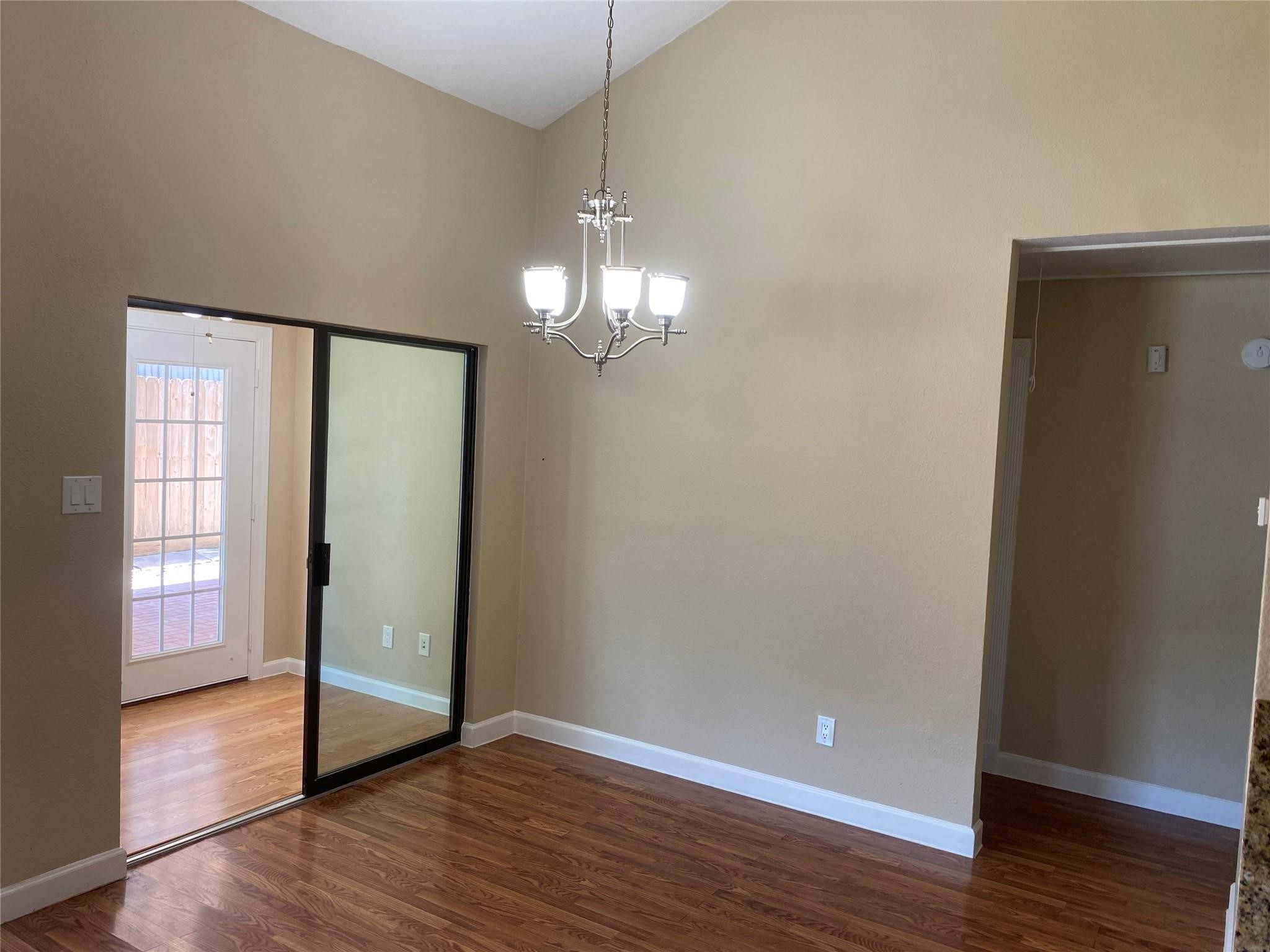 3226 Brookston Street Houston, TX 77045 - Photo 6 of 24 a view of an empty room with wooden floor and a window