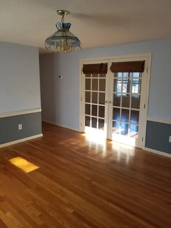 a view of empty room with wooden floor and window