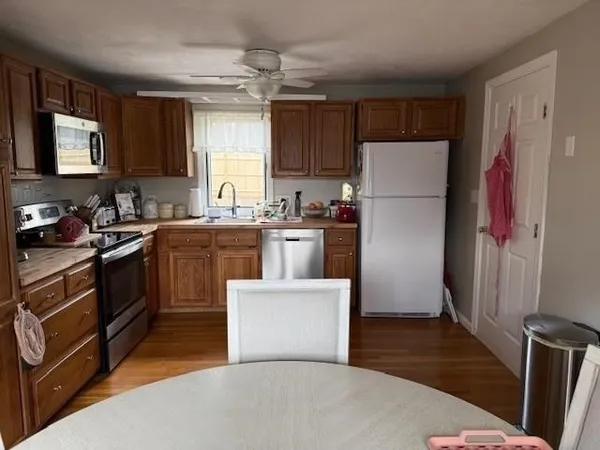 a kitchen with a sink a refrigerator a stove and wooden floor
