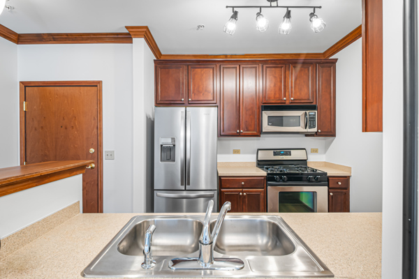 10 Ford Street, Unit 103 Geneva, IL 60134 - Photo 3 of 7 a kitchen with stainless steel appliances wooden cabinets a stove top oven a sink and dishwasher