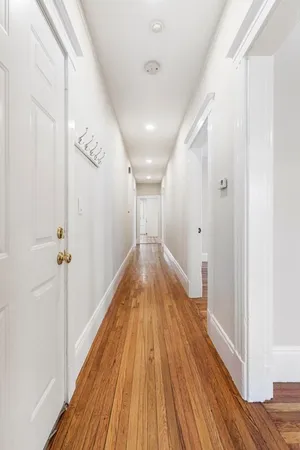 a view of a hallway with wooden floor