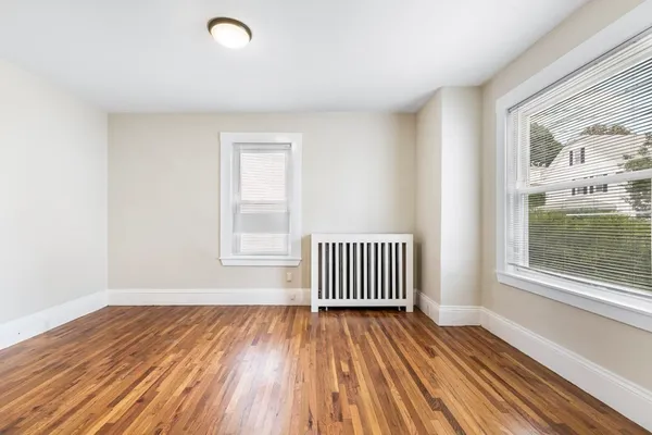 a view of a room with wooden floor and a window