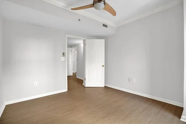 an empty room with wooden floor and windows