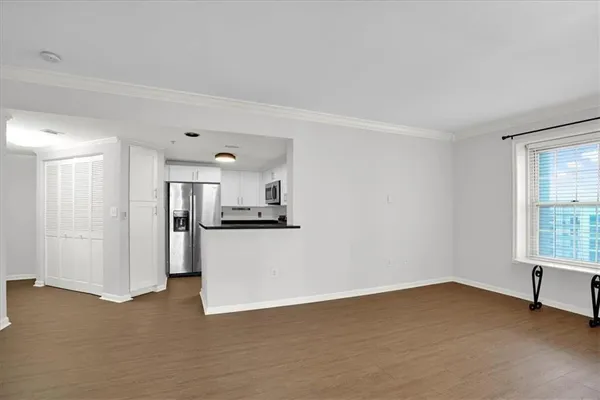 a kitchen with stainless steel appliances granite countertop a sink a refrigerator a microwave a stove and white cabinets