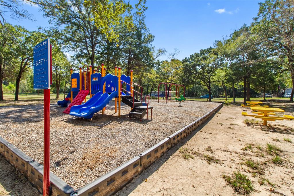 7520 Double Bridge Road Mabank, TX 75156 - Photo 31 of 32 Playground area featuring multiple slides, swings, and a spring rider