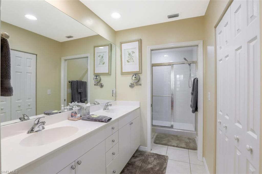 460 Launch Circle, Unit 403 Naples, FL 34108 - Photo 13 of 35 a bathroom with a double vanity sink mirror and shower
