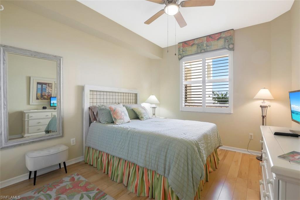 460 Launch Circle, Unit 403 Naples, FL 34108 - Photo 14 of 35 a bedroom with a bed and a table in it