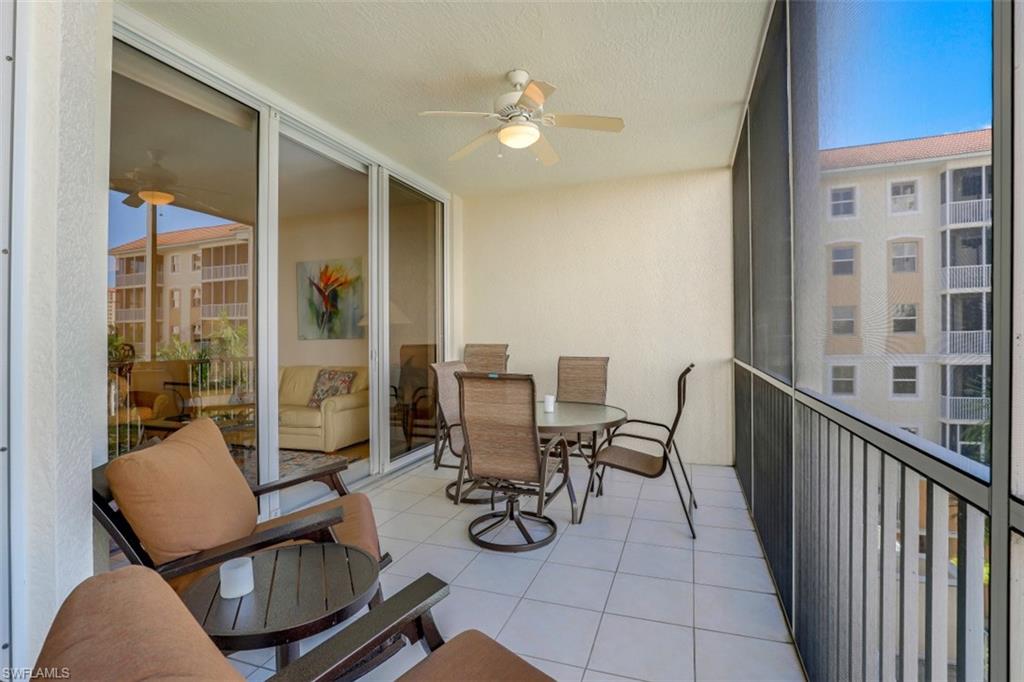 460 Launch Circle, Unit 403 Naples, FL 34108 - Photo 18 of 35 a view of a patio with table and chairs and wooden floor