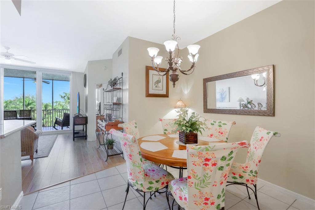 460 Launch Circle, Unit 403 Naples, FL 34108 - Photo 8 of 35 a view of a dining room with furniture a livingroom and chandelier