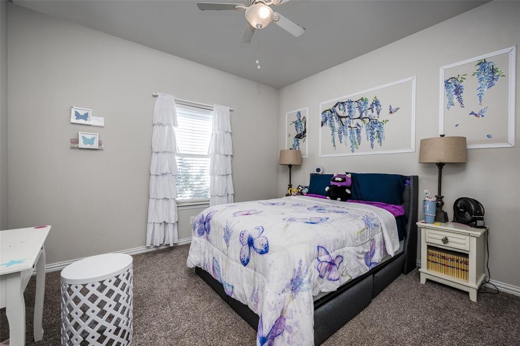 7417 Green Mesa Road Ponder, TX 76259 - Photo 24 of 39 a bedroom with a bed and a chandelier