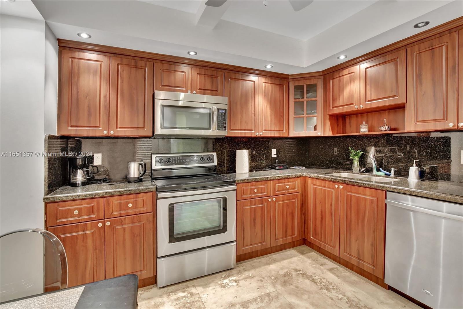 9801 Collins Avenue, Unit 3T Bal Harbour, FL 33154 - Photo 16 of 32 a kitchen with stainless steel appliances granite countertop a stove sink and cabinets