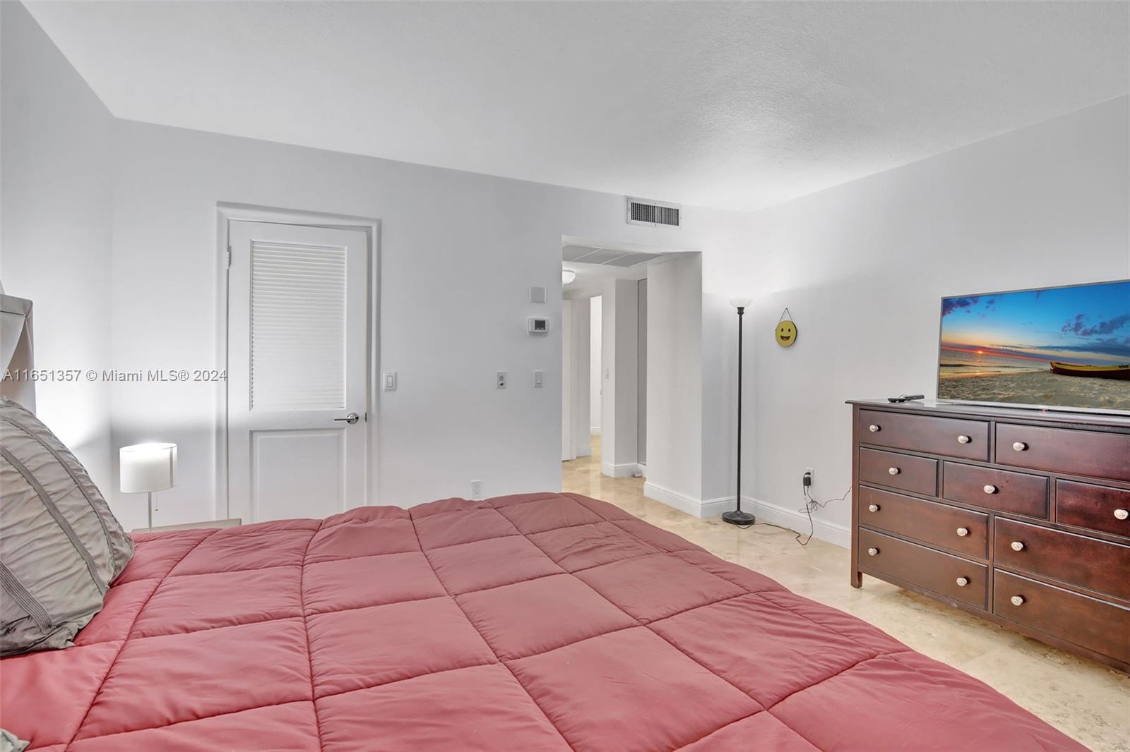 9801 Collins Avenue, Unit 3T Bal Harbour, FL 33154 - Photo 22 of 32 a bedroom with a bed and a dresser