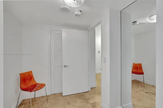 a view of a hallway with bathroom and mirror