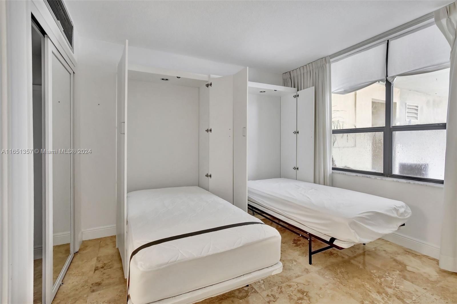 9801 Collins Avenue, Unit 3T Bal Harbour, FL 33154 - Photo 26 of 32 a bedroom with a bed and a window