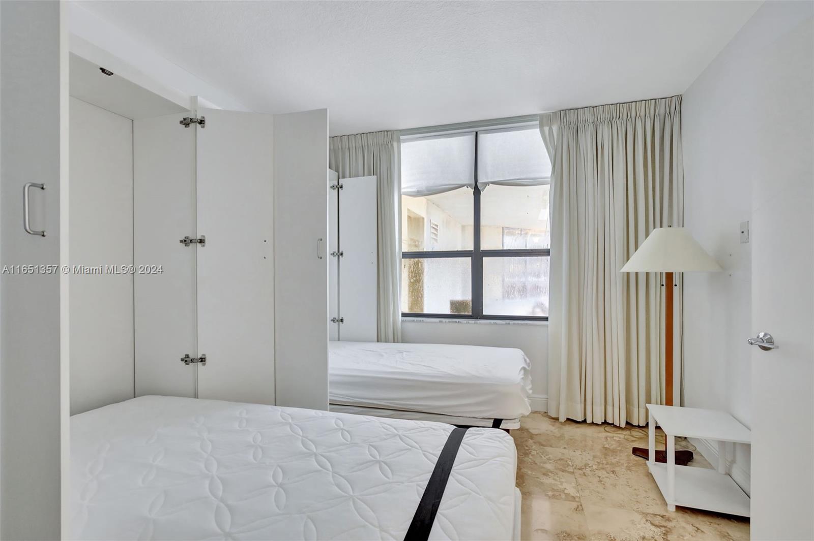 9801 Collins Avenue, Unit 3T Bal Harbour, FL 33154 - Photo 28 of 32 a bedroom with a bed and a window