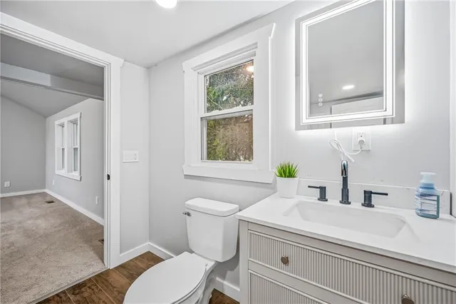 a bathroom with a sink a toilet and a window