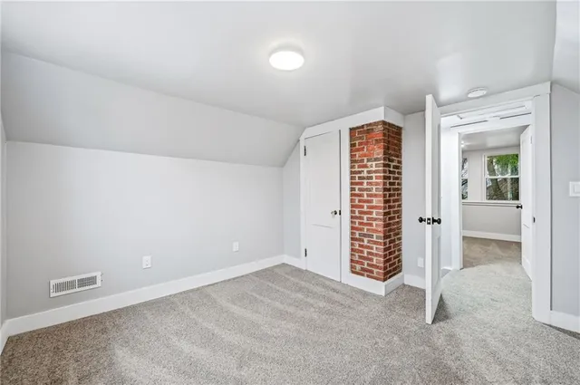 a bedroom with a bed a painting on the wall and a large window