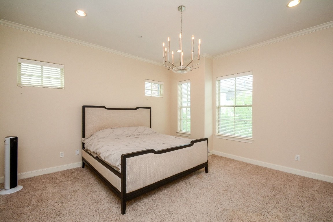 2017 Fannin Station Houston, TX 77045 - Photo 13 of 22 a spacious bedroom with a bed and a chandelier