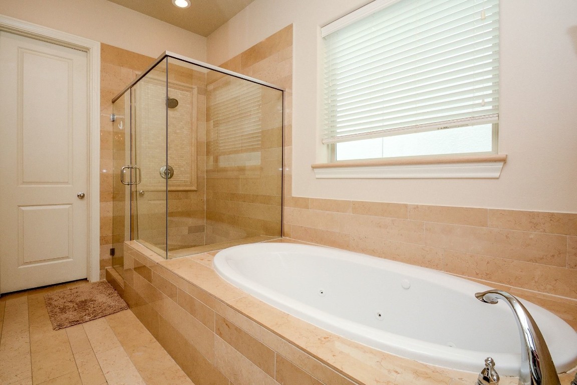 2017 Fannin Station Houston, TX 77045 - Photo 16 of 22 a bathroom with a bathtub and a shower