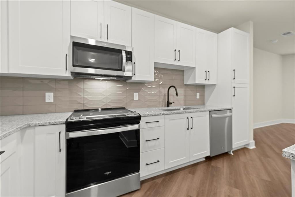 2648 Sandy Plains Road, Unit 422 Marietta, GA 30066 - Photo 8 of 37 a kitchen with stainless steel appliances granite countertop a stove a microwave and cabinets