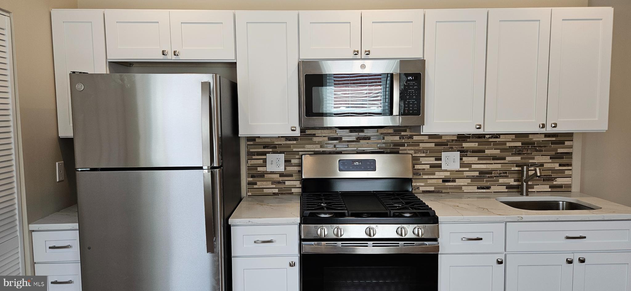 2016 1st Street Northwest, Unit 3 Washington, DC 20001 - Photo 3 of 18 a kitchen with refrigerator a stove a sink and cabinets