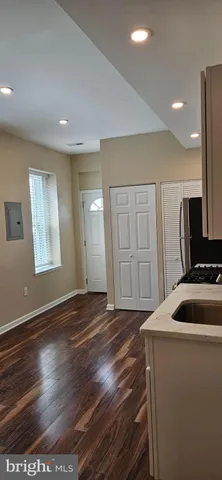a view of empty room with wooden floor