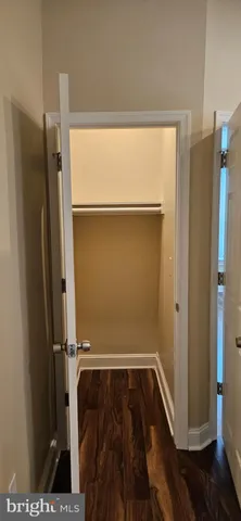 a view of walk in closet with wooden floor