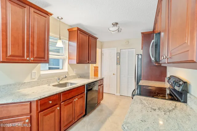 a kitchen with stainless steel appliances granite countertop a sink refrigerator and cabinets