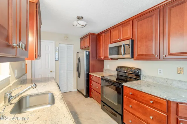 a kitchen with stainless steel appliances granite countertop a sink stove and refrigerator
