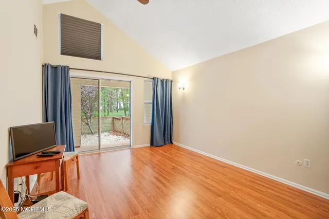 a view of a livingroom with wooden floor and a flat screen tv