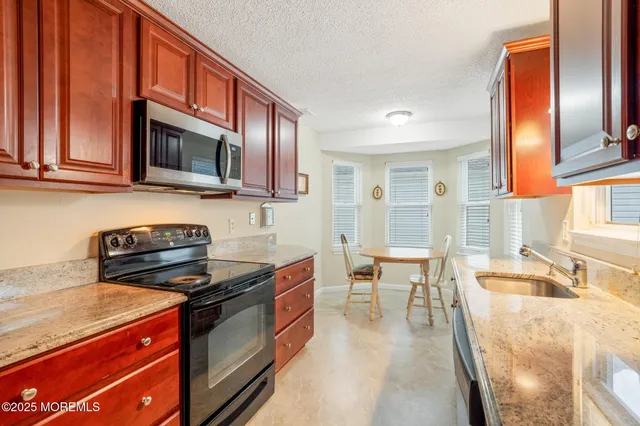 a kitchen with stainless steel appliances a stove a sink and a microwave