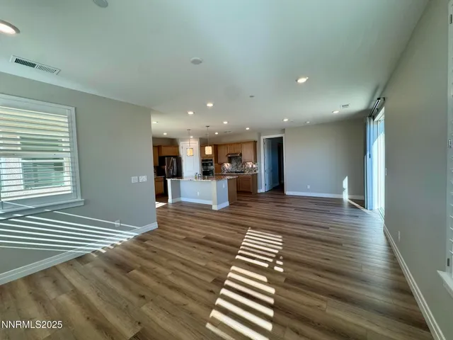 a view of a living room and kitchen with furniture wooden floor and window