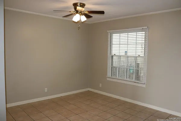 an empty room with windows and fan
