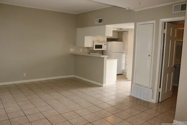 a kitchen with white cabinets and refrigerator