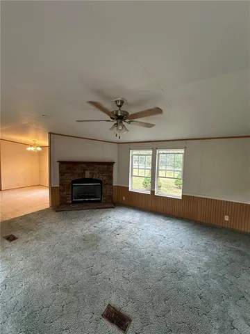 an empty room with windows and ceiling fan