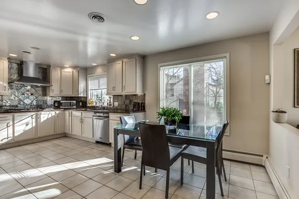 a kitchen with a table chairs refrigerator and cabinets