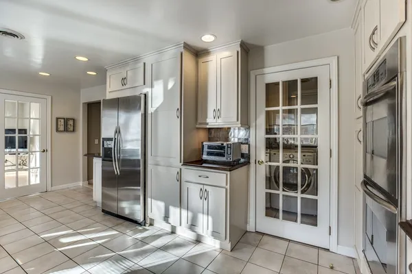 a kitchen with stainless steel appliances granite countertop a refrigerator and a sink