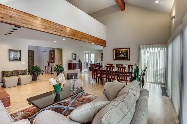 a living room with furniture kitchen view and a large window