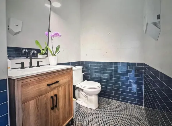 a bathroom with a sink a toilet and a mirror