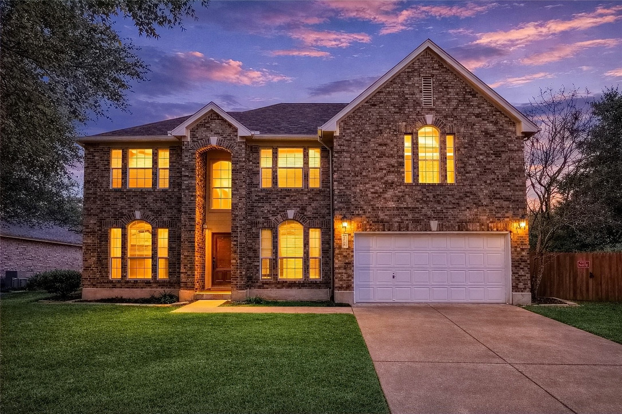 4008 Springwillow Lane Round Rock, TX 78681 - Photo 18 of 29 View of front home at dusk featuring driveway, an attached garage, and brick siding
